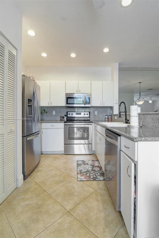 kitchen with white cabinets, appliances with stainless steel finishes, decorative backsplash, and sink