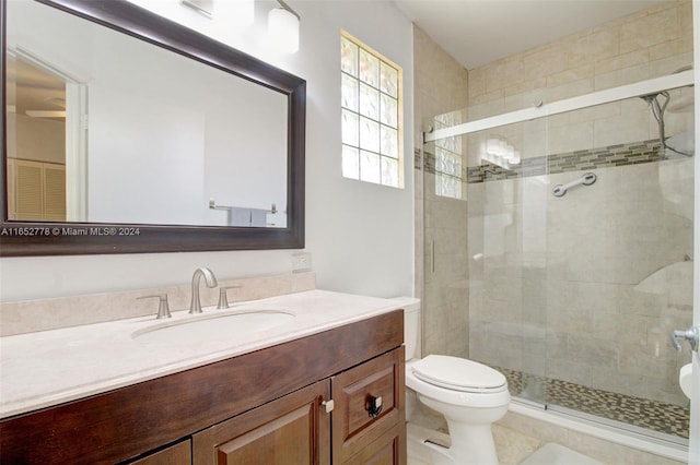 bathroom featuring vanity, toilet, a shower with shower door, and tile patterned floors