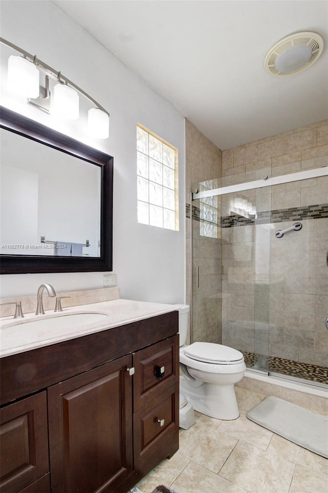 bathroom featuring vanity, toilet, and walk in shower