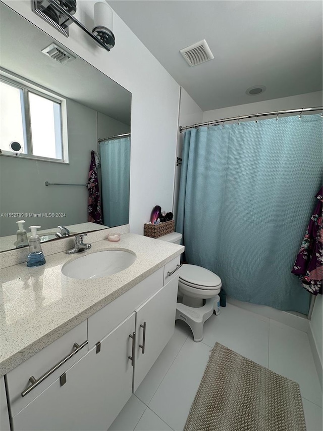 bathroom with tile patterned flooring, vanity, and toilet