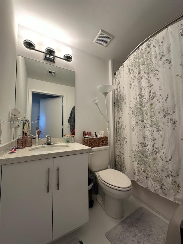 bathroom featuring tile patterned flooring, a shower with curtain, vanity, and toilet