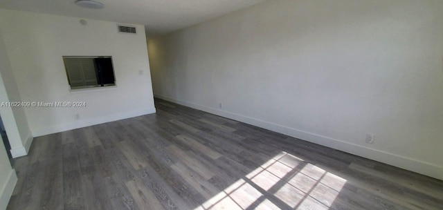 unfurnished living room featuring dark wood-type flooring