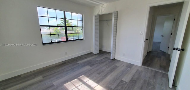 unfurnished bedroom featuring hardwood / wood-style flooring and a closet