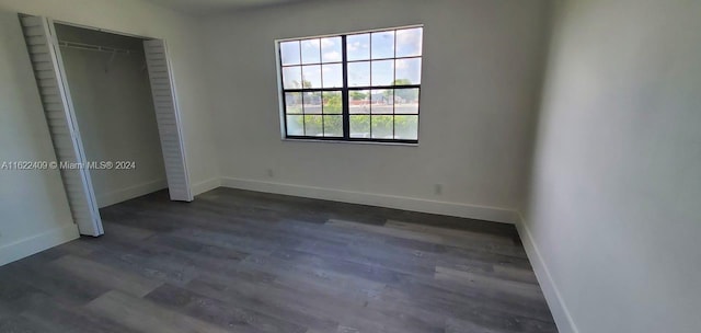 unfurnished bedroom with a closet and dark hardwood / wood-style floors