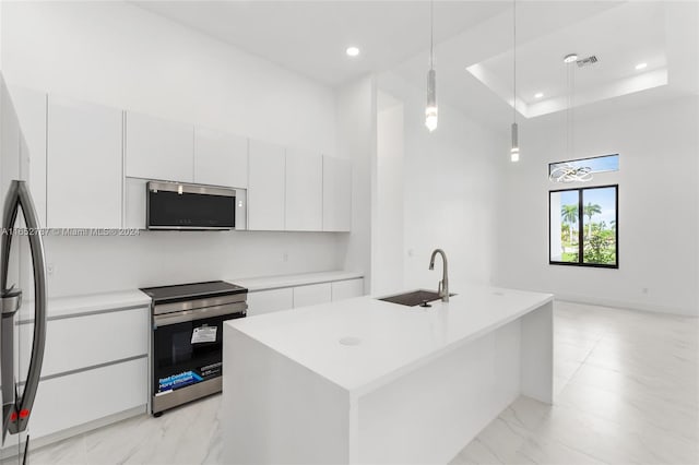 kitchen with decorative light fixtures, stainless steel appliances, white cabinetry, and sink