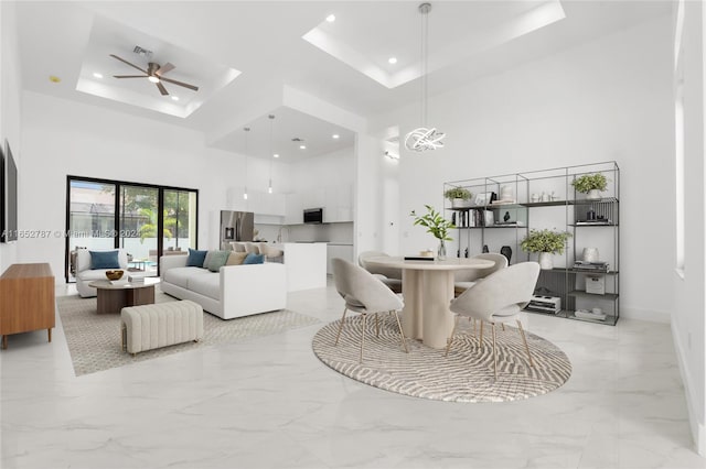 interior space featuring a high ceiling, a tray ceiling, and ceiling fan