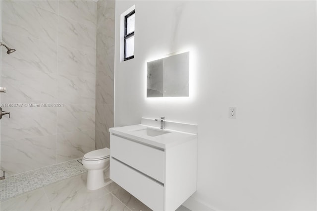 bathroom featuring tiled shower, vanity, and toilet