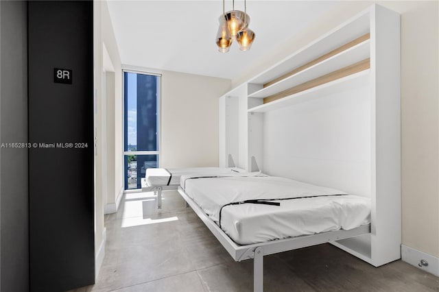 bedroom featuring concrete floors and a wall of windows