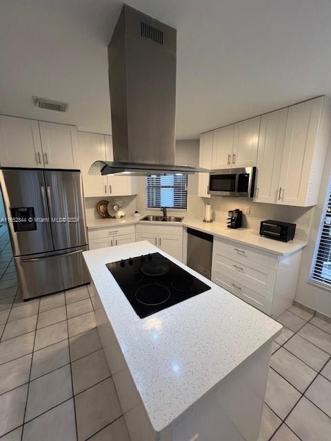 kitchen with white cabinetry, light tile patterned floors, stainless steel appliances, island range hood, and sink