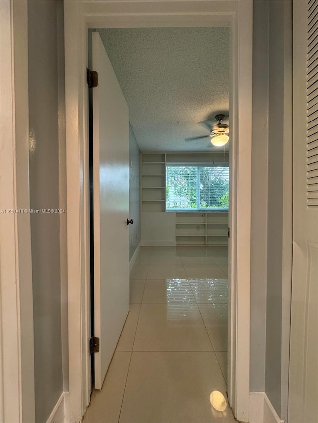 hall with light tile patterned floors and a textured ceiling