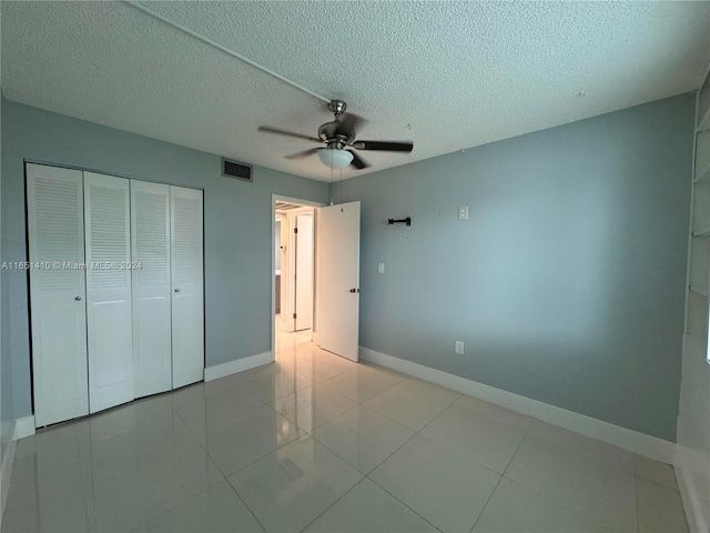 unfurnished bedroom with a textured ceiling, ceiling fan, and light tile patterned floors