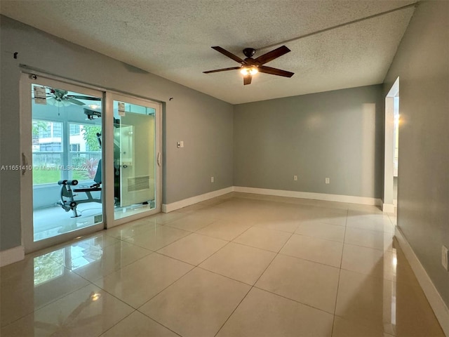 tiled empty room featuring a textured ceiling and ceiling fan