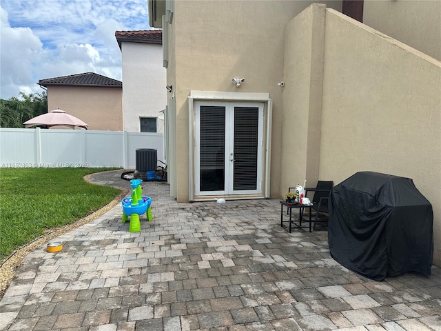 view of patio with cooling unit, a grill, and french doors