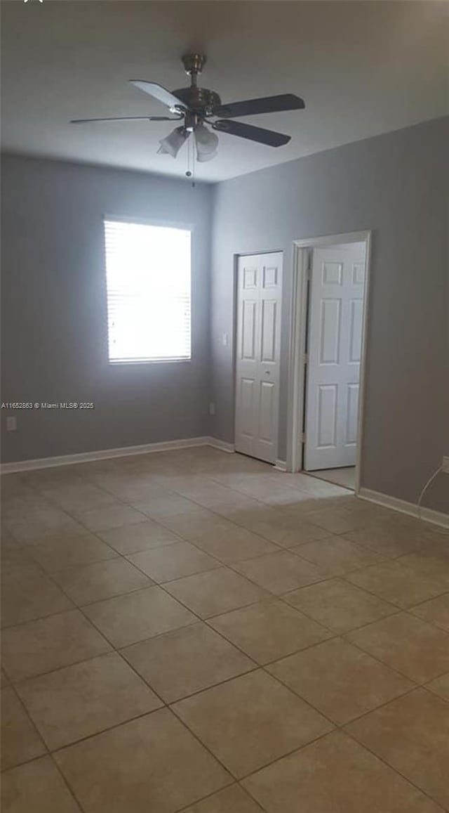 empty room featuring light tile patterned floors and ceiling fan