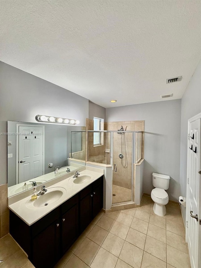 bathroom with tile patterned flooring, a textured ceiling, toilet, a shower with shower door, and vanity