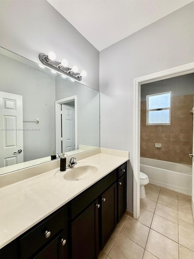 full bathroom with tiled shower / bath combo, toilet, tile patterned floors, and vanity