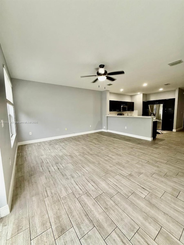 unfurnished living room featuring ceiling fan