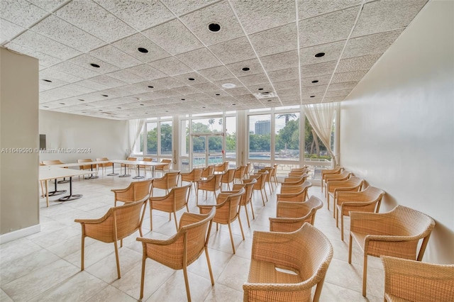 tiled dining area featuring a drop ceiling