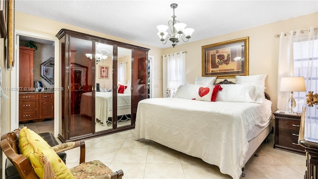 bedroom featuring light tile patterned floors, a textured ceiling, and a notable chandelier