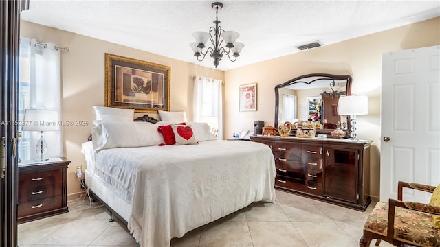 bedroom featuring light tile patterned floors, a textured ceiling, and an inviting chandelier