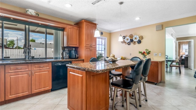 kitchen featuring sink, hanging light fixtures, black dishwasher, a textured ceiling, and a kitchen island