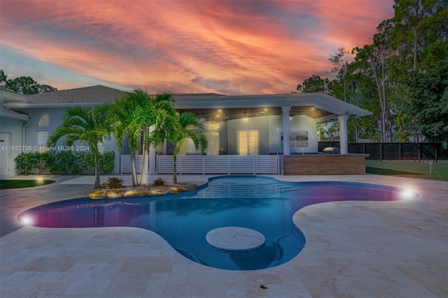 pool at dusk with a patio area