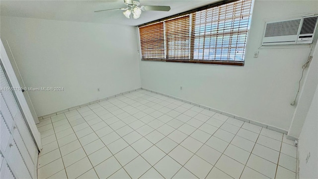 unfurnished bedroom with ceiling fan, light tile patterned floors, and an AC wall unit