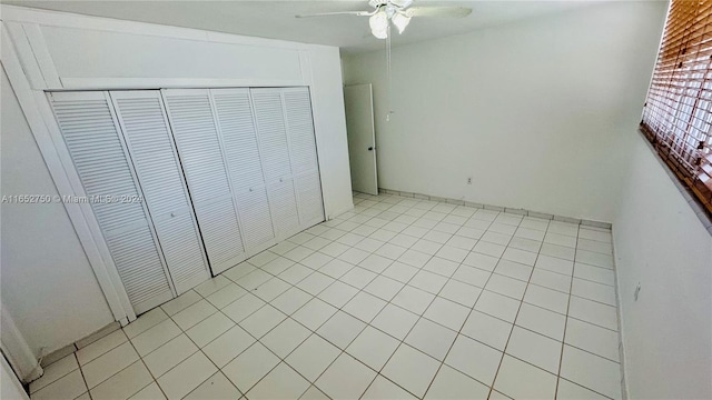 unfurnished bedroom with ceiling fan, a closet, and light tile patterned flooring