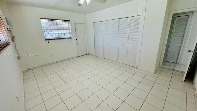 unfurnished bedroom with light tile patterned flooring, ceiling fan, and a closet