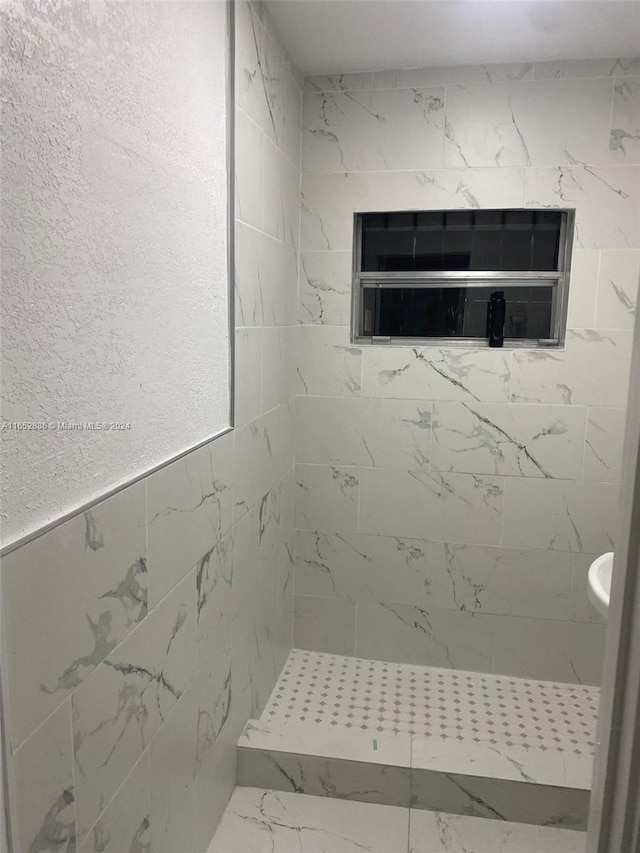 bathroom featuring a tile shower