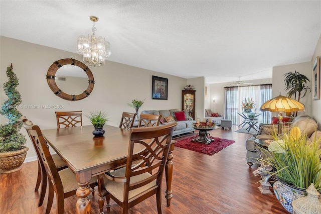 dining area with a textured ceiling, a chandelier, and hardwood / wood-style floors