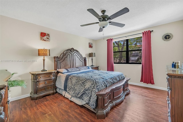 bedroom featuring dark wood-type flooring, a textured ceiling, and ceiling fan