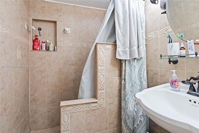 bathroom featuring tile walls and sink