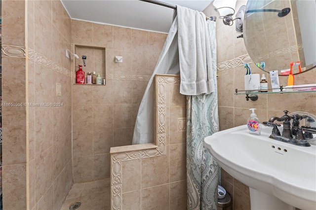 bathroom featuring tile walls, walk in shower, and sink