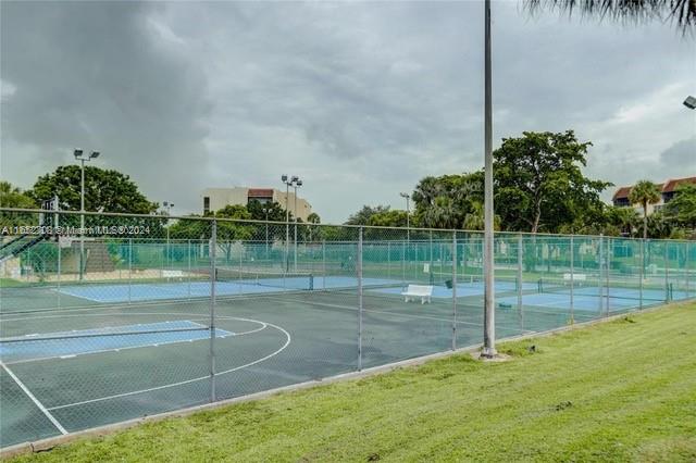 view of sport court with a yard