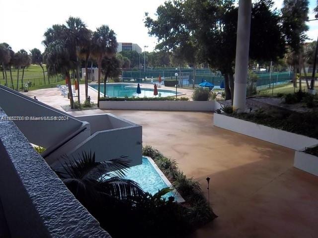 view of home's community featuring a pool and a patio