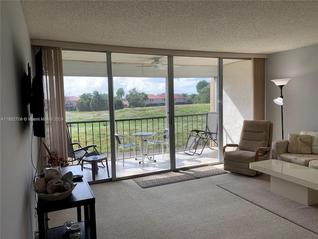 carpeted living room featuring a textured ceiling, floor to ceiling windows, and ceiling fan