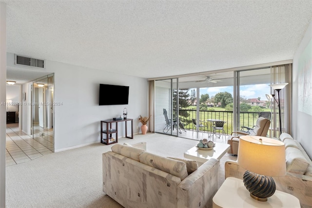 carpeted living room featuring floor to ceiling windows, ceiling fan, and a textured ceiling