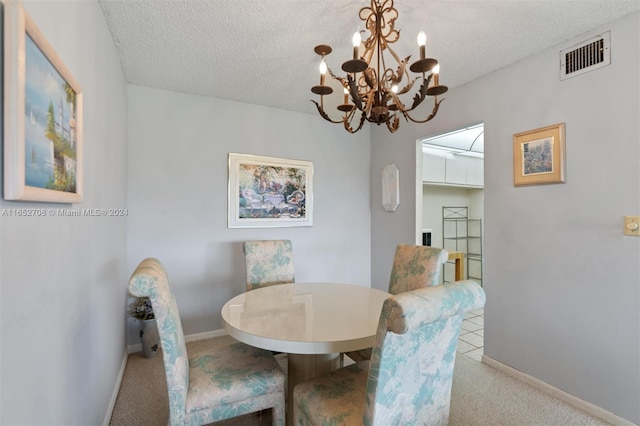 carpeted dining room with a chandelier and a textured ceiling