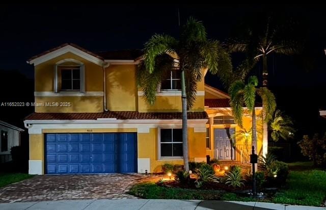 view of front of home with a garage, decorative driveway, and stucco siding