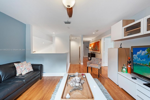 living area featuring light wood finished floors, recessed lighting, visible vents, and baseboards