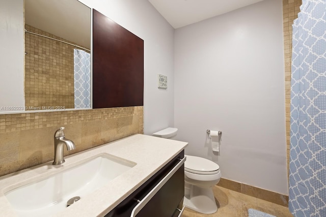 bathroom featuring toilet, curtained shower, decorative backsplash, and vanity