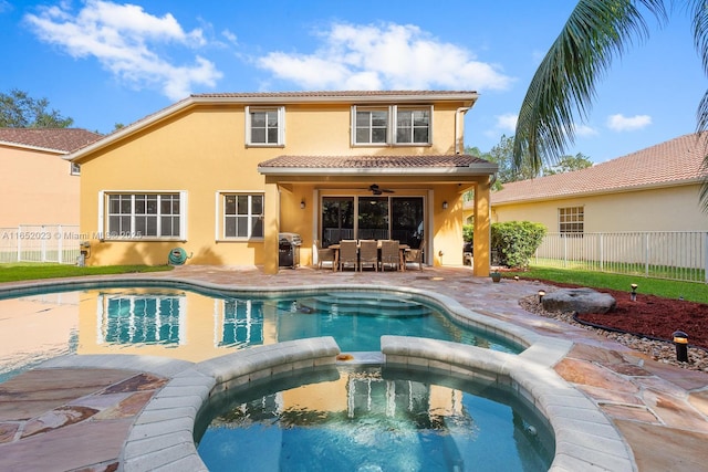 rear view of property featuring a ceiling fan, a patio area, fence, and stucco siding