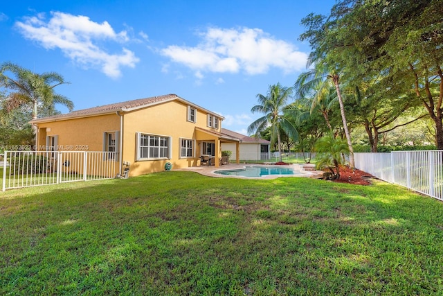 back of property featuring a yard, a fenced backyard, a fenced in pool, and stucco siding