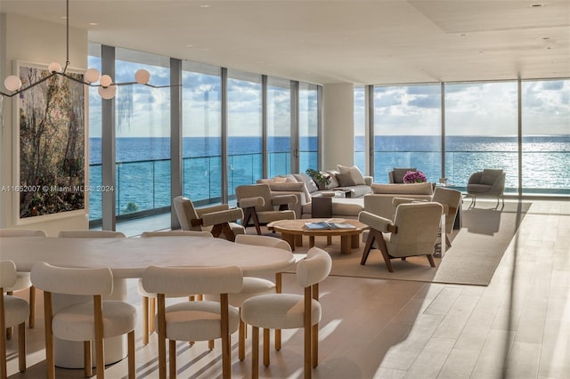 interior space featuring a water view, expansive windows, and hardwood / wood-style flooring