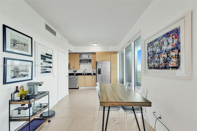 dining space featuring light tile patterned floors and sink