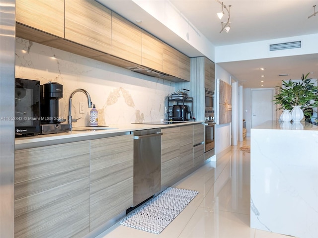 kitchen featuring appliances with stainless steel finishes, rail lighting, backsplash, and sink