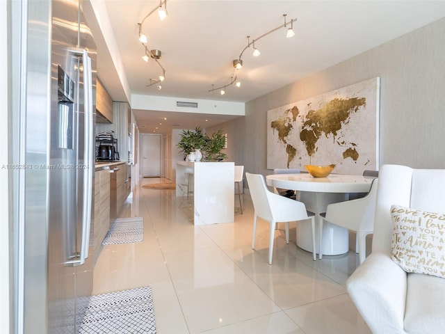 dining area featuring rail lighting and light tile patterned floors