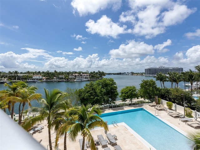 view of swimming pool featuring a water view and a patio area