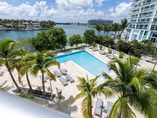 view of swimming pool featuring a water view, a patio area, and central air condition unit